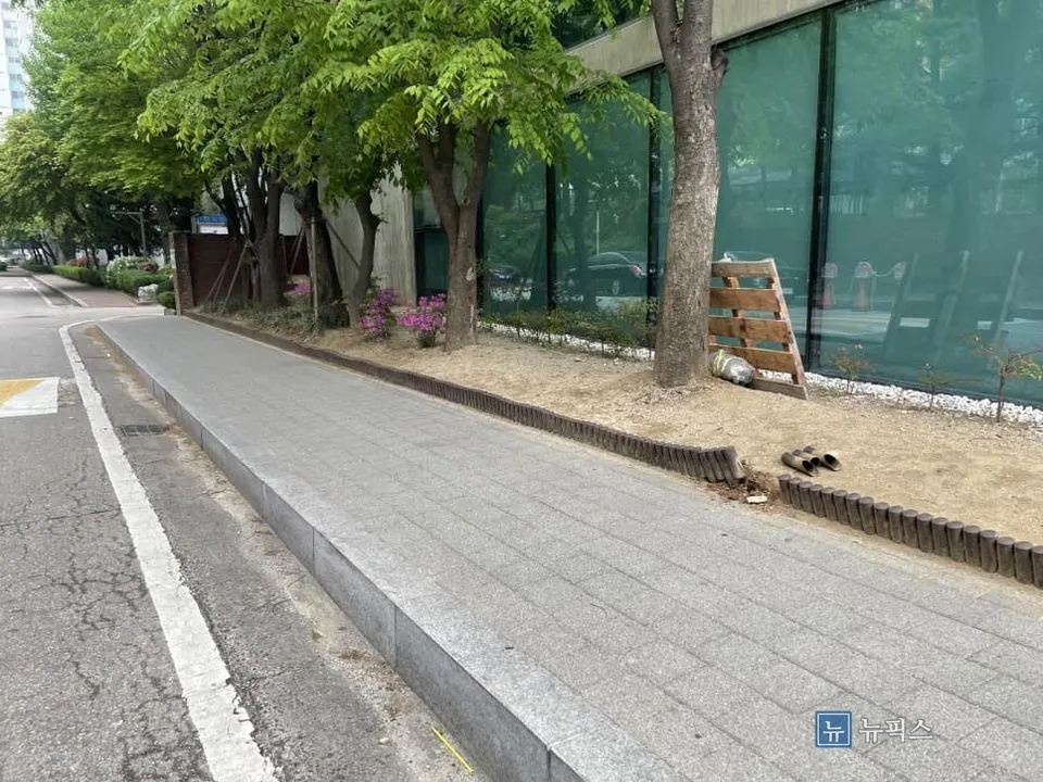 보도블럭과 맞닿은 작업 전 화단, 낮은 플라스틱 울타리가 설치된 모습