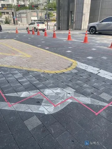 침하 구간을 분홍색 테이프로 표시해 둔 단지 입구 보도블럭