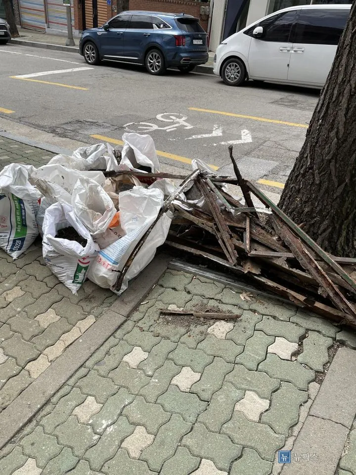 마대에 담은 폐기물과 철거한 트렌치 잔해를 보도에 모아 놓은 모습
