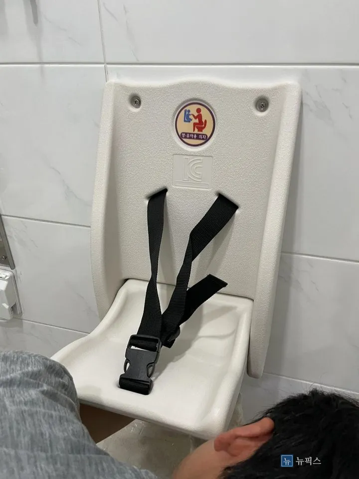 벽에 고정된 영유아거치대와 안전벨트 버클