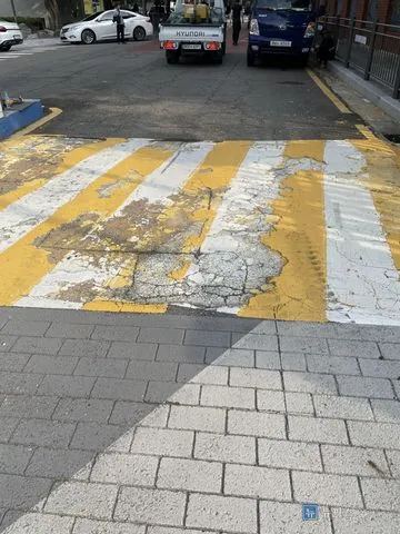 표면이 깨지고 도색이 벗겨진 아파트 출입구 방지턱