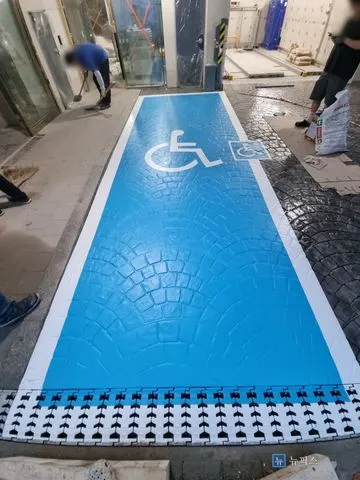 흰색 테두리와 휠체어 픽토그램까지 마친 장애인주차구역