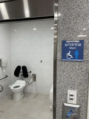 남자화장실 표지판 옆으로 보이는 장애인화장실 내부