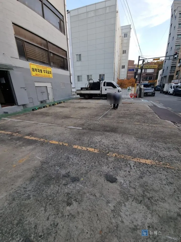갈라지고 패인 자국이 남아 있는 보수 전 주차장 콘크리트 바닥