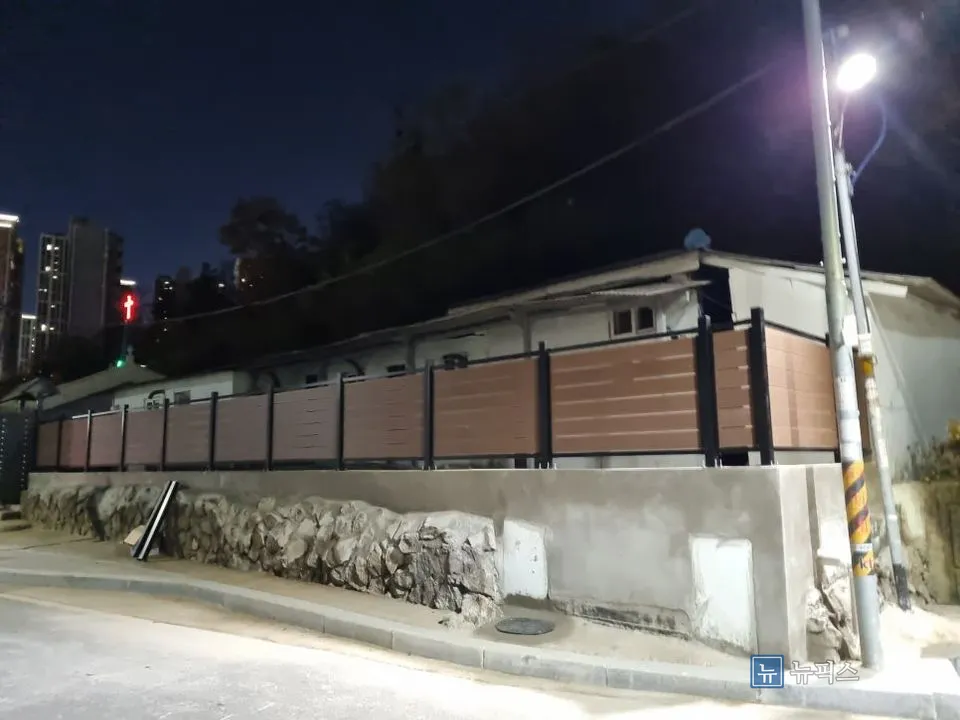 조명 아래에서 본 목재 휀스와 새로 시공한 담벼락 전경