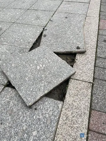 깨져 들린 인도 화강석 타일과 드러난 흙바닥