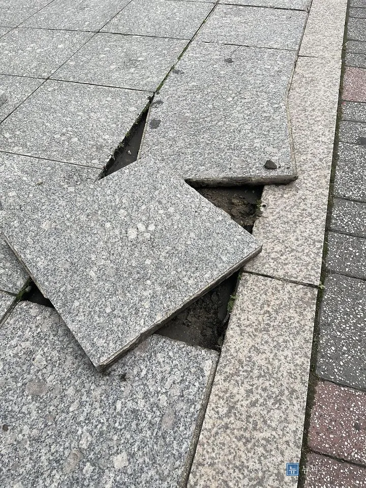 깨져 들린 인도 화강석 타일과 드러난 흙바닥