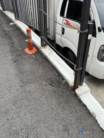 난간이 끊긴 주차장 입구 턱과 기존에 설치된 고무 탄성볼라드 한 개
