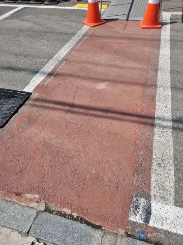 색이 바래고 가장자리가 벗겨진 주차장 보행로 바닥
