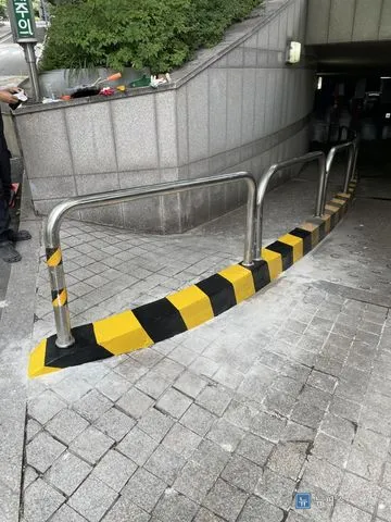스텐 휀스를 세우고 노랑·검정 사선 도색까지 마친 중앙분리턱