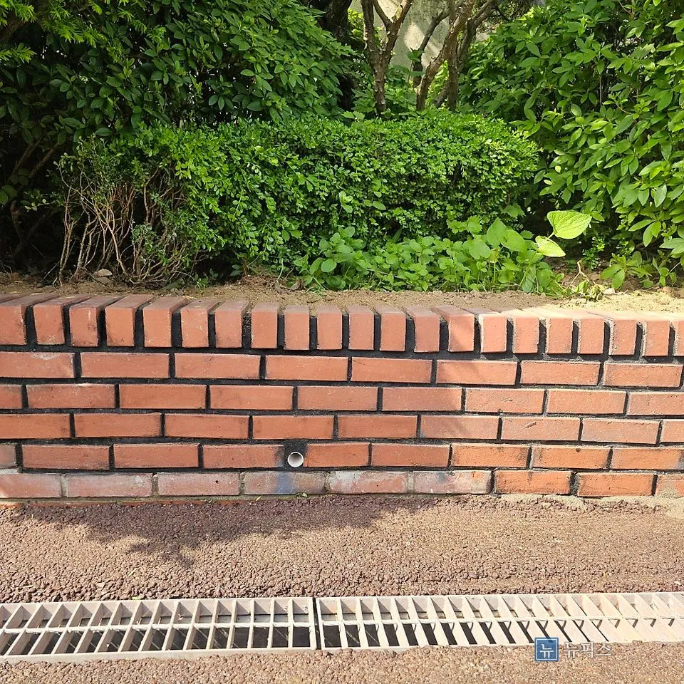 재조적을 마친 화단 담장 정면, 하단에 물구멍이 보임